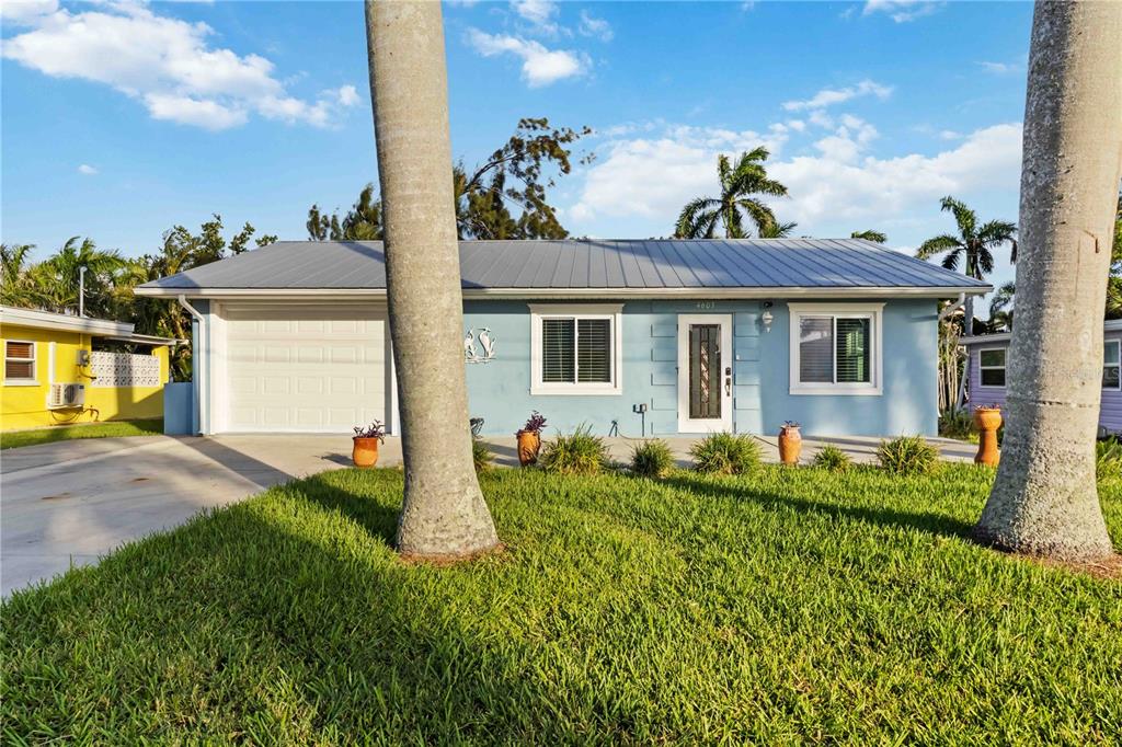 A light blue single-story house with a metal roof and a white garage door — 4603 103RD STREET W, BRADENTON, FL