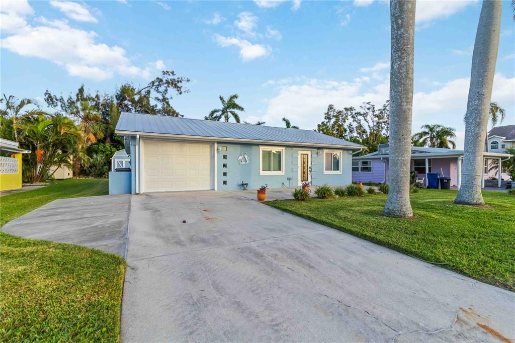 A light blue single-story house with a metal roof and a concrete driveway — 4603 103RD STREET W, BRADENTON, FL
