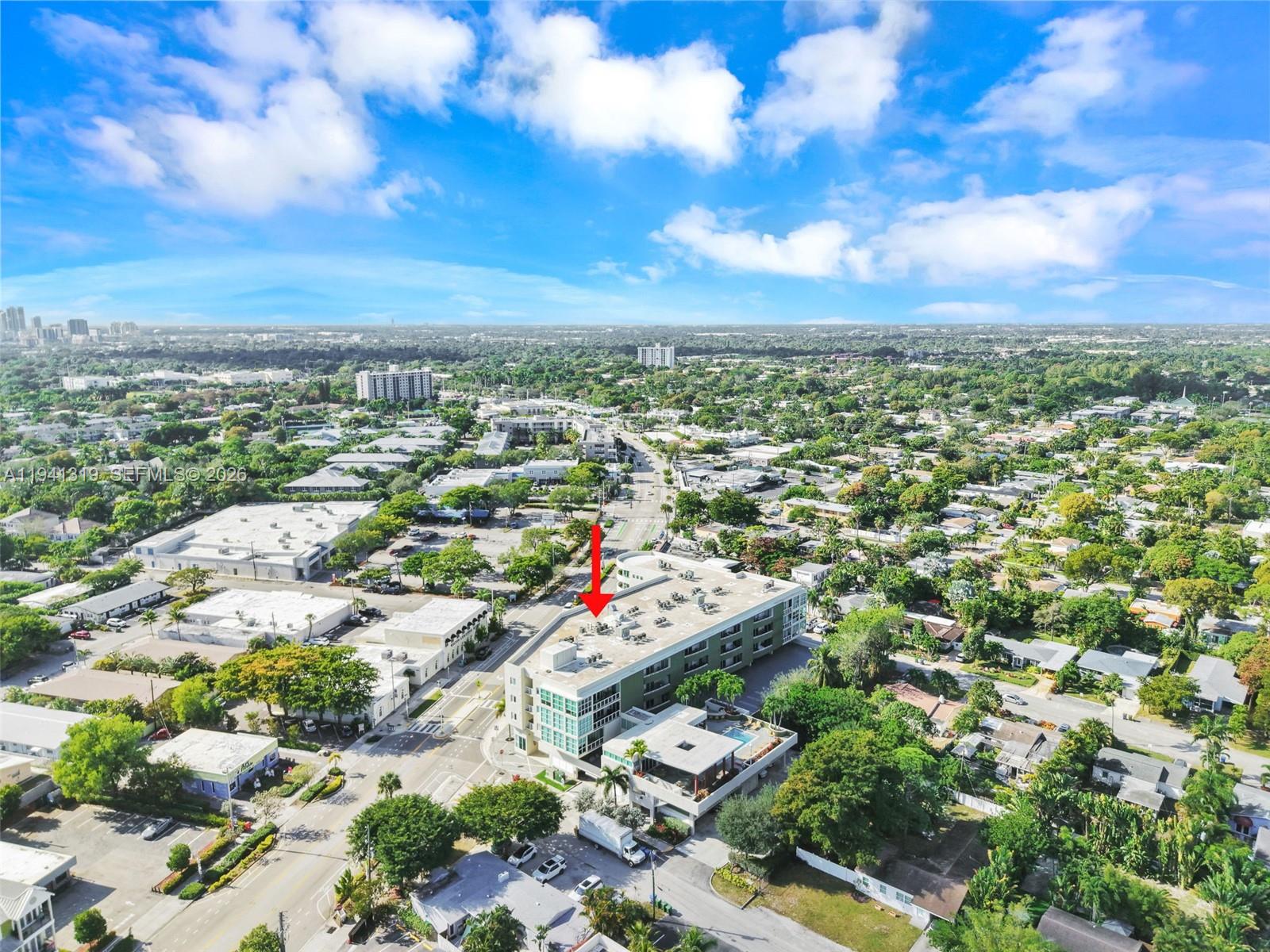 An aerial view shows a multi-story apartment building with a rooftop pool and surrounding neighborhood — 2301 Wilton Dr # C5, Wilton Manors FL 33305, WILTON MANORS, FL