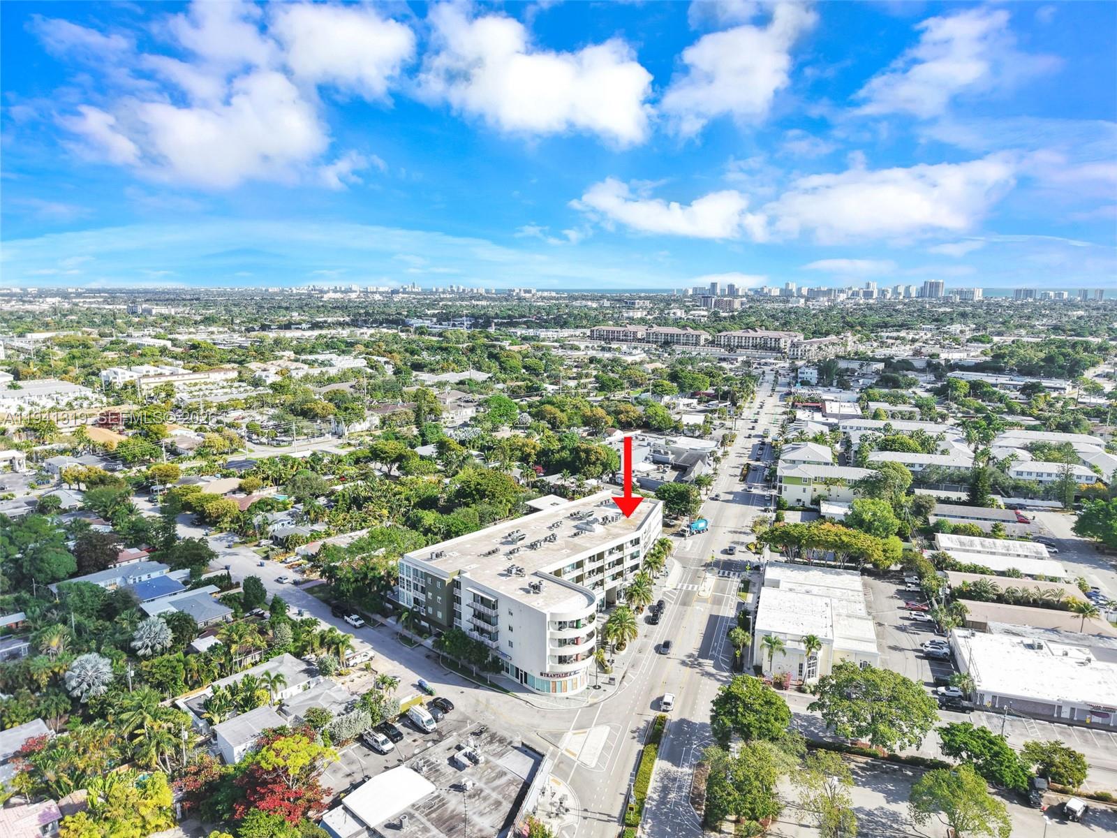 An aerial view shows a multi-story apartment building with a curved facade near a street — 2301 Wilton Dr # C5, Wilton Manors FL 33305, WILTON MANORS, FL