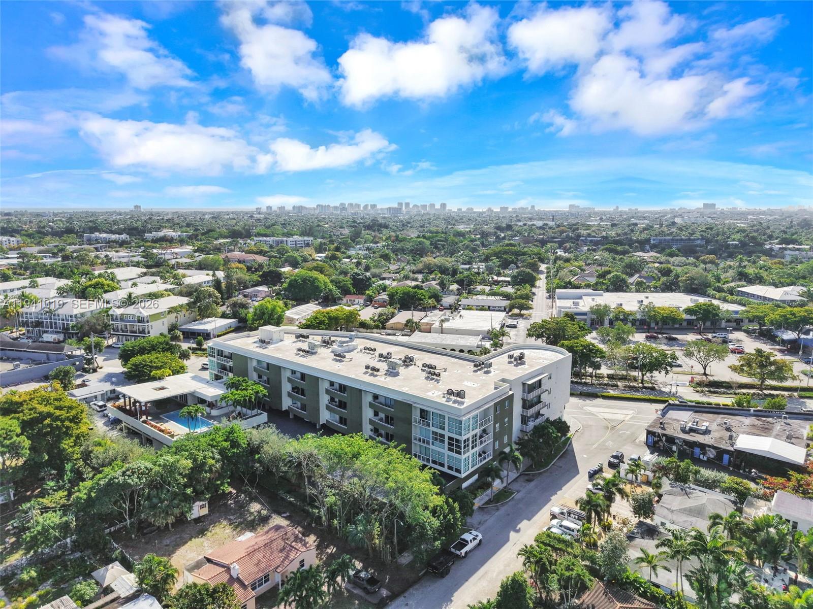 An aerial view shows a multi-story apartment building with a pool and surrounding neighborhood — 2301 Wilton Dr # C5, Wilton Manors FL 33305, WILTON MANORS, FL