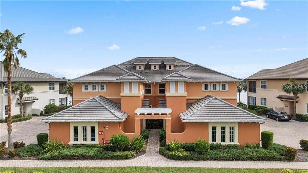 A two-story orange stucco building with a gray tiled roof and a central walkway — 1143 RIVERSCAPE STREET UNIT A, BRADENTON, FL