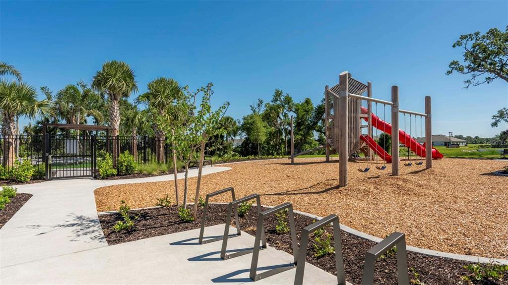 A kitchen with white cabinets, stainless steel appliances, and a quartz-topped island — 13135 BENDING CREEK TRAIL, PALMETTO, FL