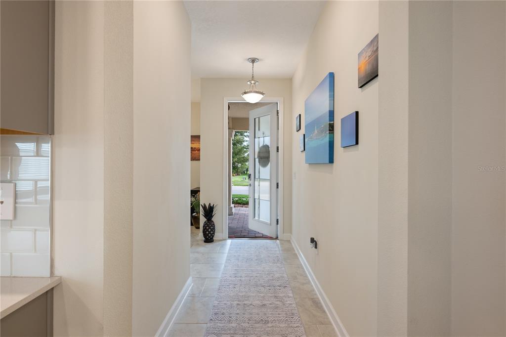 A tiled hallway leads to an open front door with a view of the outdoors — 8926 FALLEN OAK DRIVE, DAVENPORT, FL