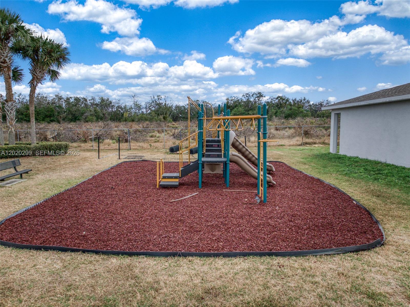 A playground with slides and climbing equipment sits on a red mulch surface outdoors — 1407 Las Villas Blvd # 1407, Sebring FL 33870, SEBRING, FL