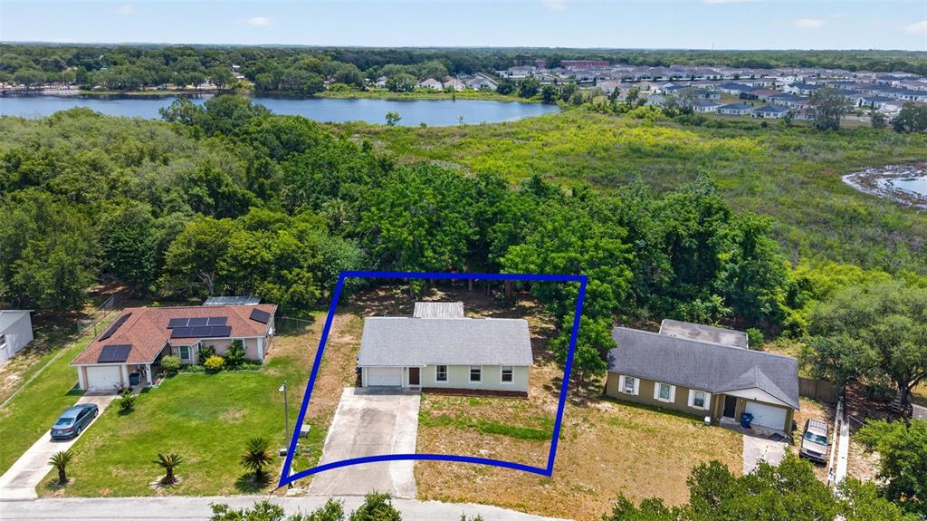 An aerial view shows a single-story house with a gray roof and driveway — 36 BAY RIDGE LOOP, MASCOTTE, FL