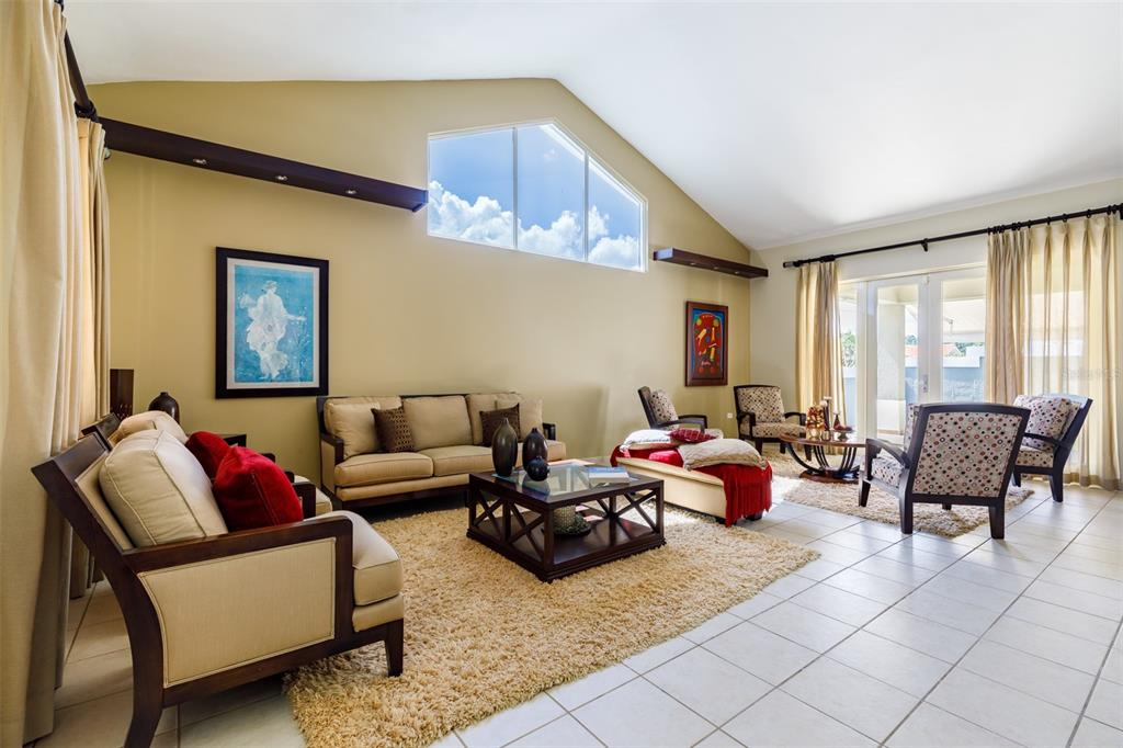 A living room with a vaulted ceiling, tiled floors, a large area rug, and furniture — 121 CAMINOS DE LOS LOTOS SABANERA, DORADO, PR