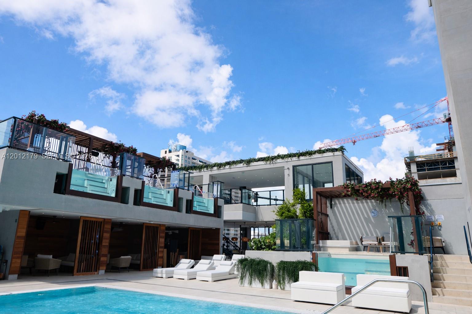 An outdoor pool deck features lounge chairs, a small pool, and modern multi-level building structures — 20 NE 11 th st # 3403A, Miami FL 33132, MIAMI, FL