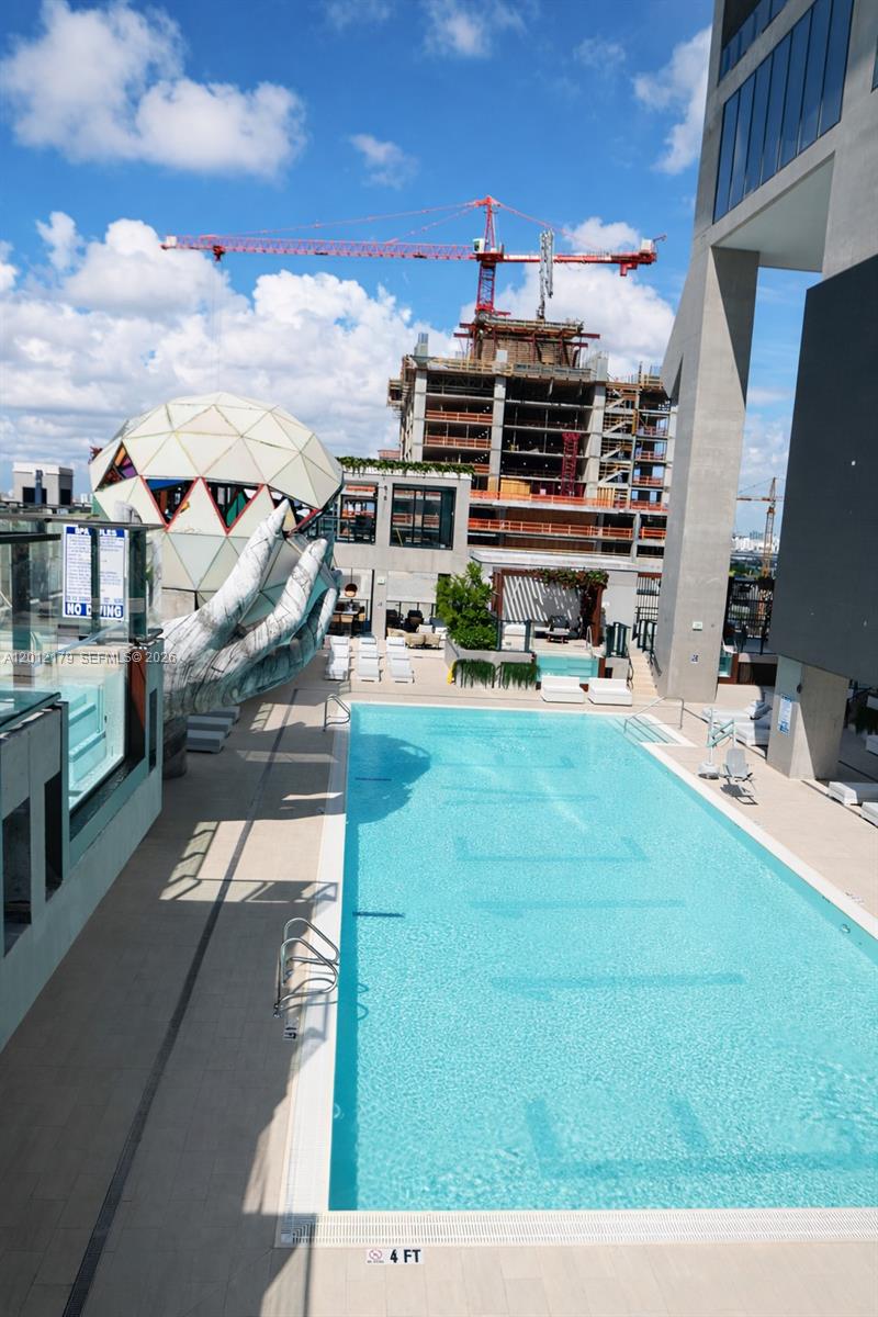 A rooftop swimming pool features a large sculptural hand holding a geometric sphere — 20 NE 11 th st # 3403A, Miami FL 33132, MIAMI, FL