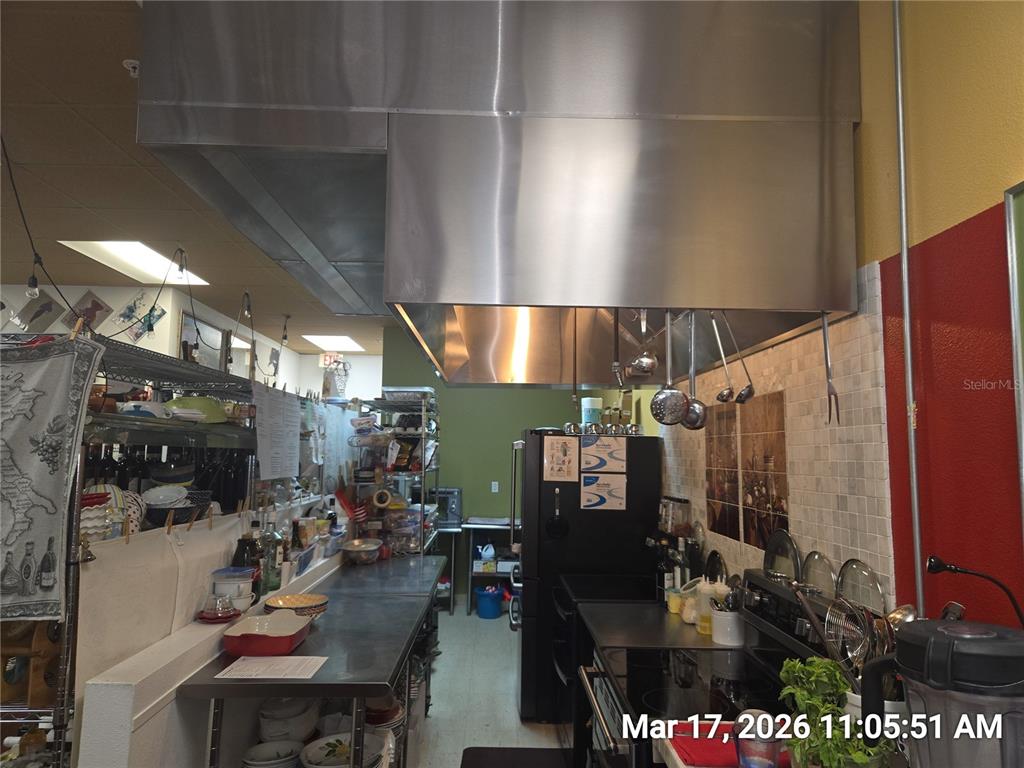 A commercial kitchen features stainless steel prep tables, a large ventilation hood, and appliances — 0000 BRANDON BOULEVARD, BRANDON, FL
