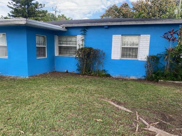 A blue single-story house with white-trimmed windows and a lawn in the foreground — 14291 Polk Street, Miami FL 33176, MIAMI, FL