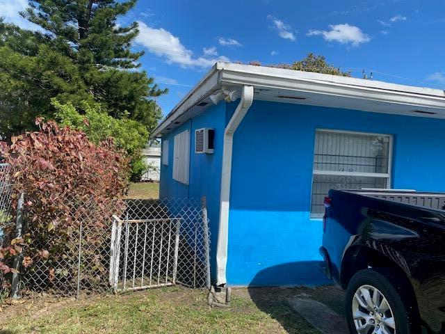 A bright blue house exterior features a chain-link fence and a black pickup truck parked nearby — 14291 Polk Street, Miami FL 33176, MIAMI, FL