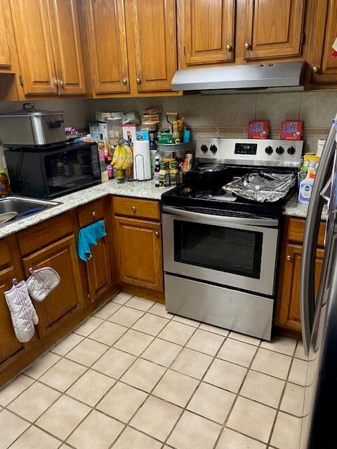 A kitchen features wood cabinets, stainless steel appliances, and light-colored tile flooring — 14291 Polk Street, Miami FL 33176, MIAMI, FL