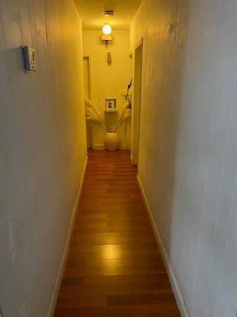 A narrow hallway features white vertical paneled walls, wood-look flooring, and a central light fixture — 14291 Polk Street, Miami FL 33176, MIAMI, FL