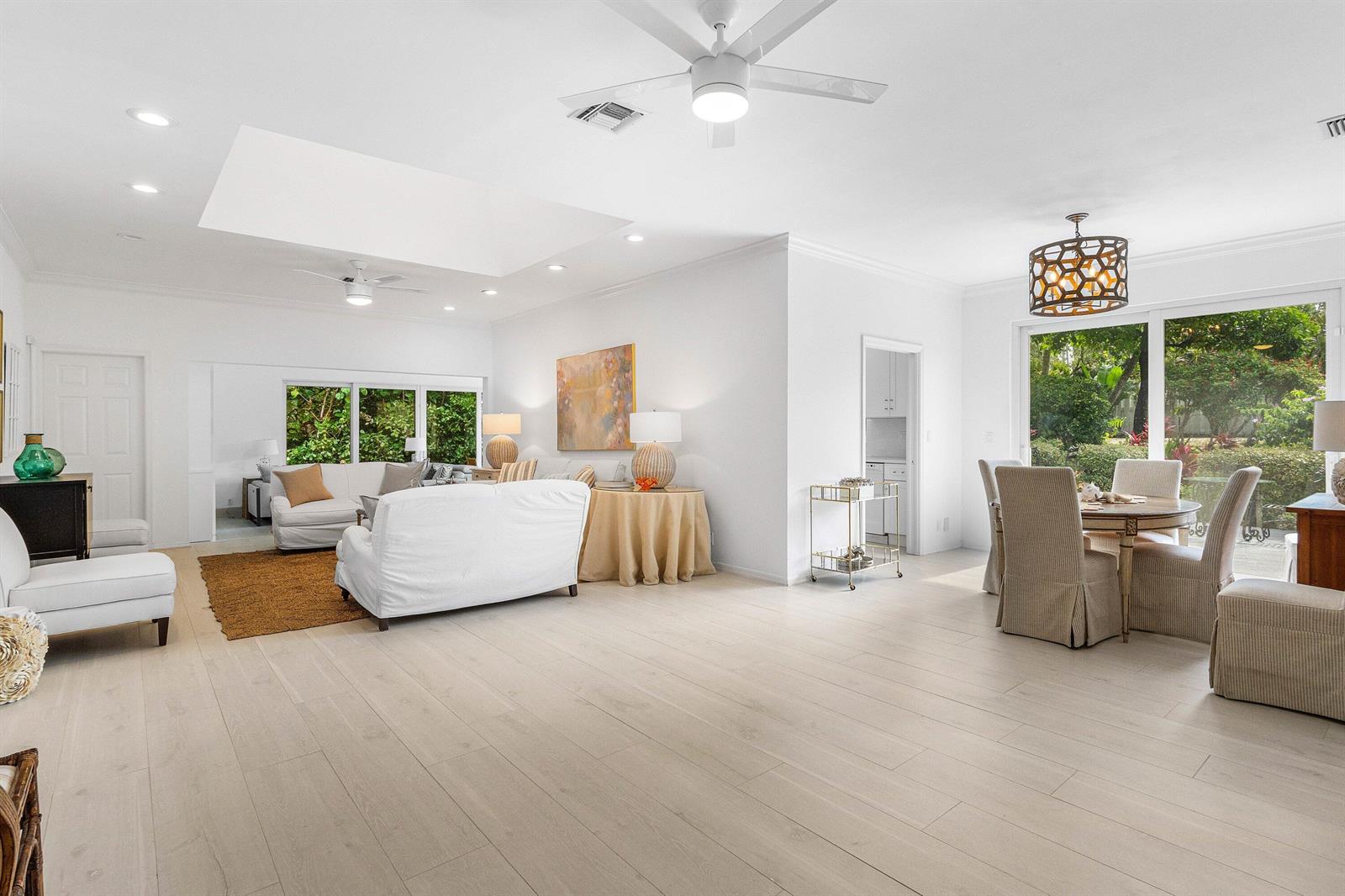 A bright, open-concept living and dining area features white walls, light wood floors, and windows — 1100 N Ocean Boulevard, Gulf Stream FL 33483, GULF STREAM, FL