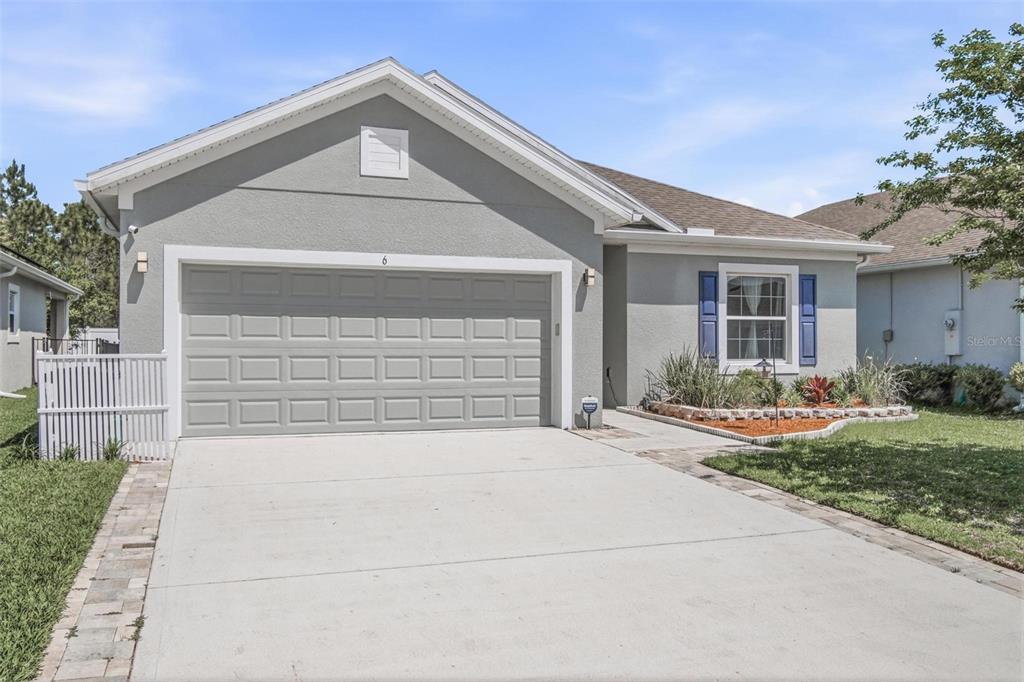 A single-story house with a gray stucco exterior, a two-car garage, and blue shutters — 6 OAKLEAF WAY, PALM COAST, FL