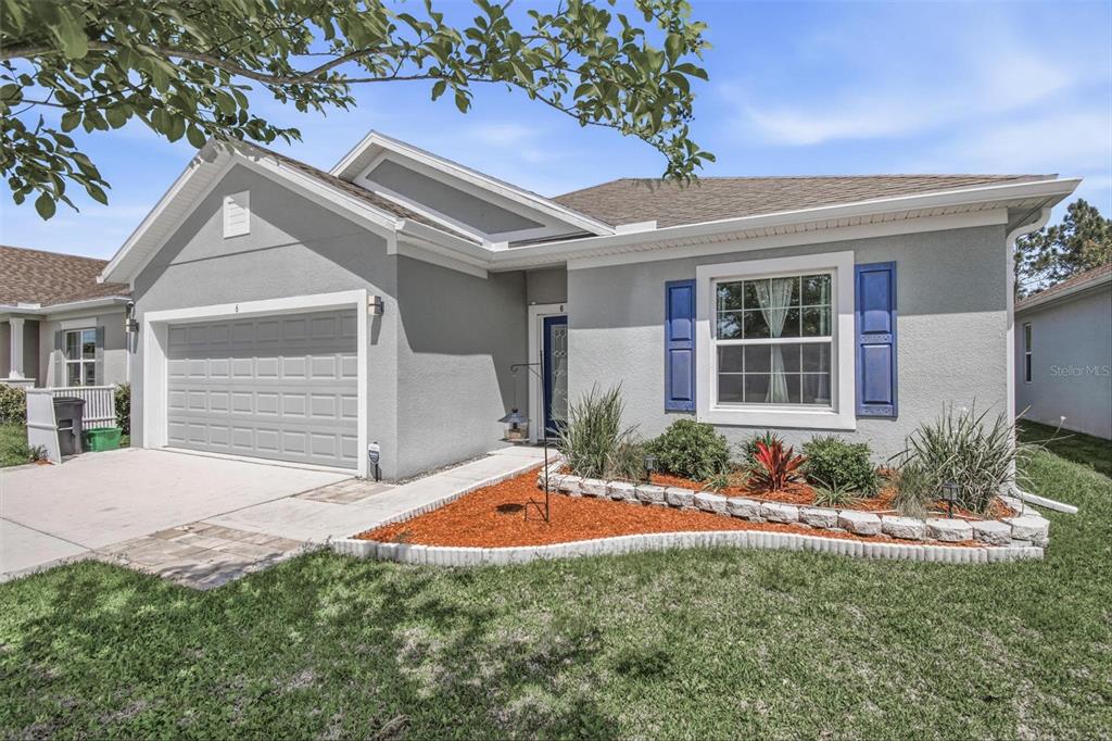 A single-story house with a gray stucco exterior, blue shutters, and a front-facing garage — 6 OAKLEAF WAY, PALM COAST, FL