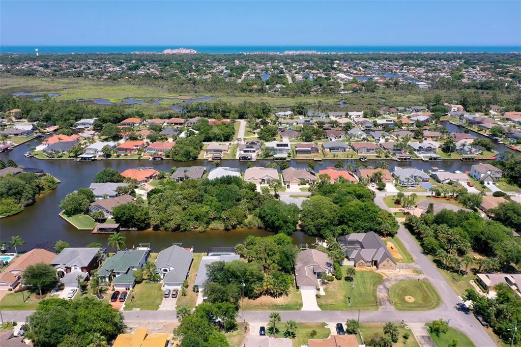 An aerial view shows a residential neighborhood with houses situated along a canal — 6 CORONA COURT, PALM COAST, FL