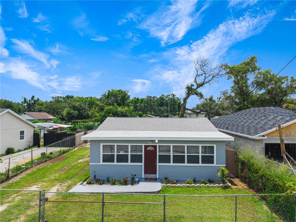 A gray, single-story house with a red front door and a chain-link fence — 910 18TH STREET, ORLANDO, FL