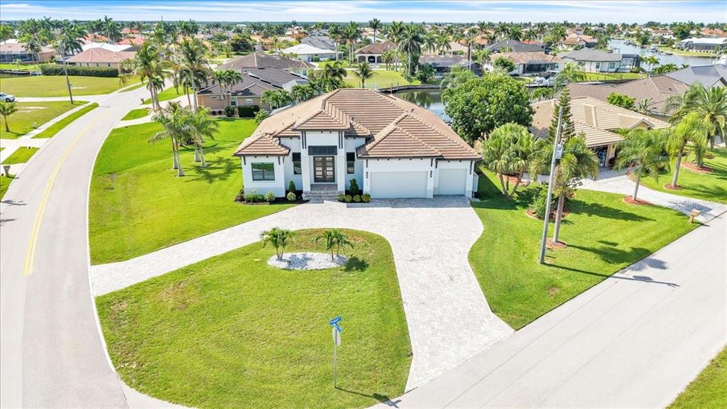 An aerial view of a single-story house with a tiled roof and a paved driveway — 1323 PENGUIN COURT, PUNTA GORDA, FL