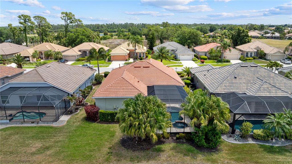 An aerial view shows several suburban houses with tiled roofs, screened-in pools, and landscaped yards — 2725 ROYAL PALM DRIVE, NORTH PORT, FL