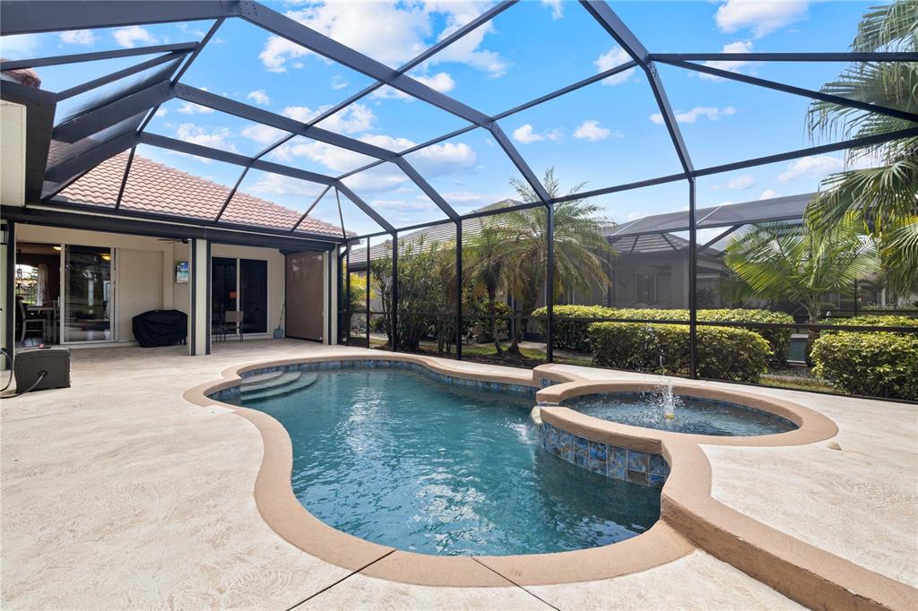 A screened-in patio features a swimming pool with an attached spa and fountain — 2725 ROYAL PALM DRIVE, NORTH PORT, FL