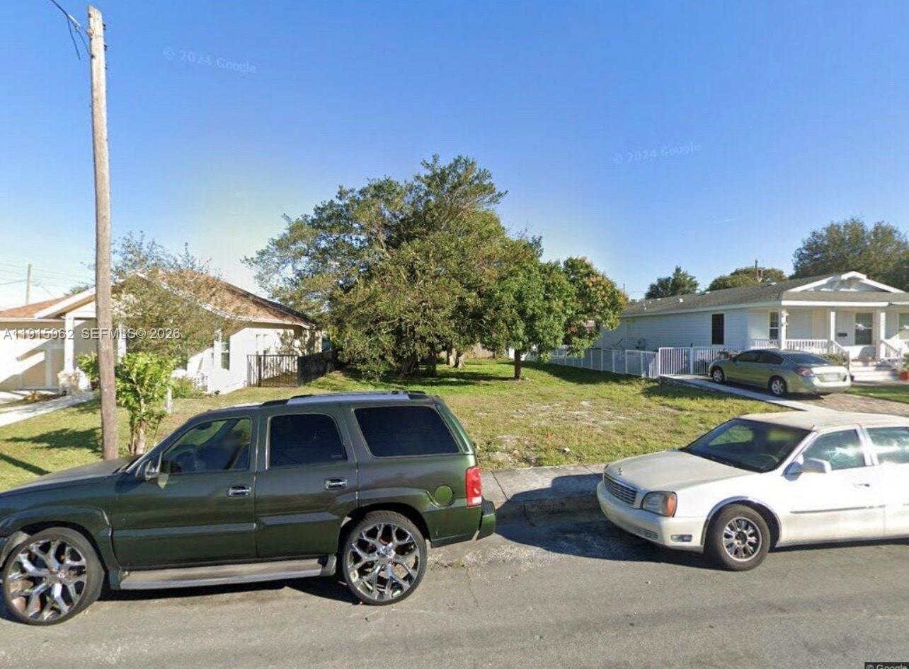 A vacant grassy lot sits between two single-story houses on a residential street — 913 14th St, West Palm Beach FL 33401, WEST PALM BEACH, FL