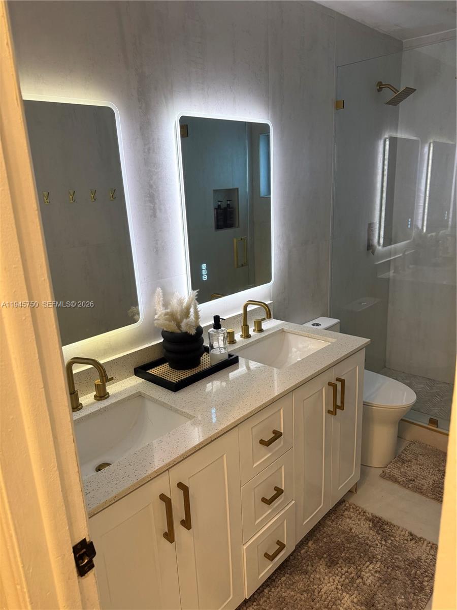A bedroom features a bed with a beige headboard, white nightstands, and light wood flooring — 7770 NW 45th Ct, Lauderhill FL 33351, LAUDERHILL, FL
