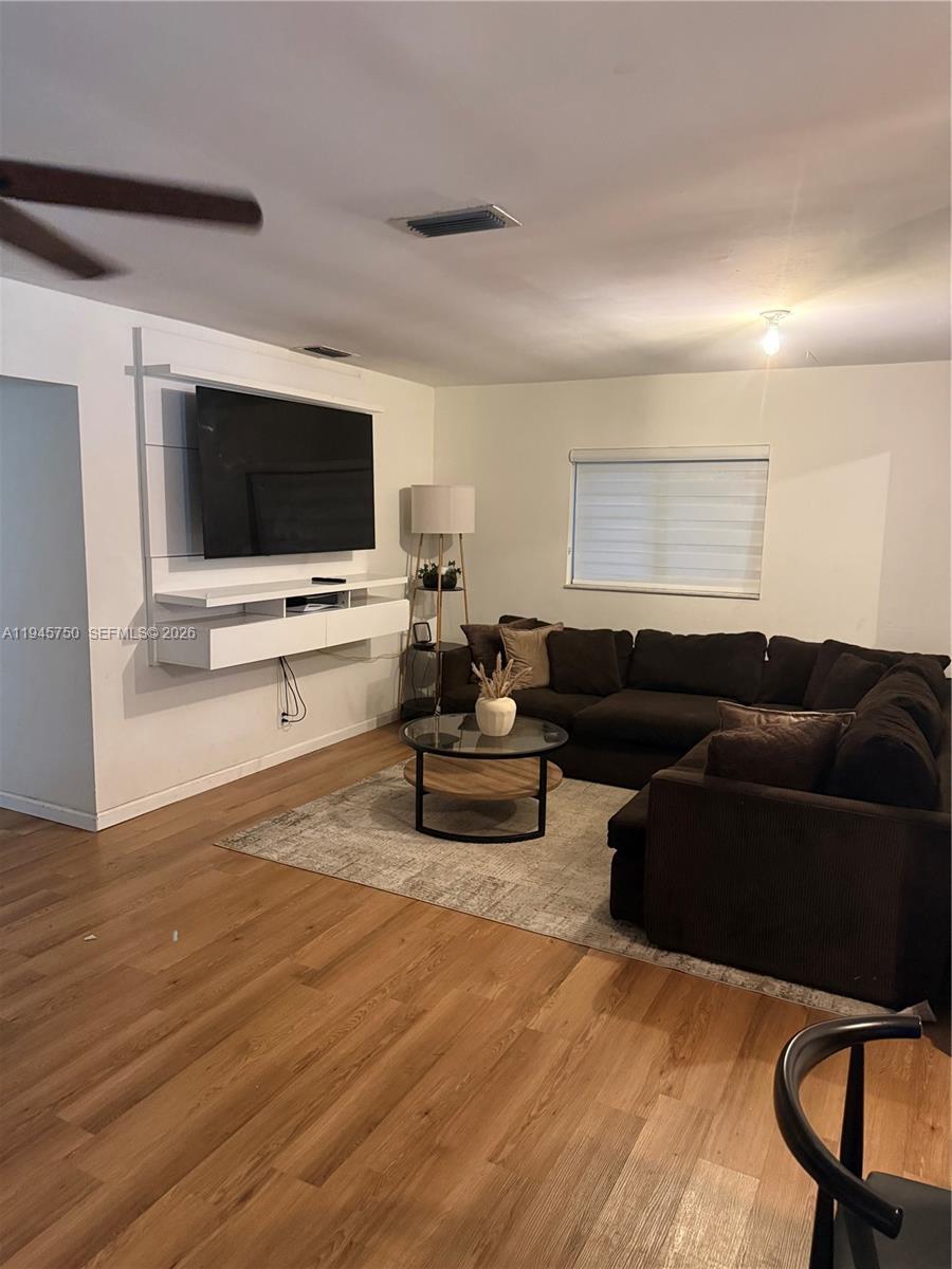 A modern kitchen features white cabinetry, stainless steel appliances, and a large marble-topped island — 7770 NW 45th Ct, Lauderhill FL 33351, LAUDERHILL, FL