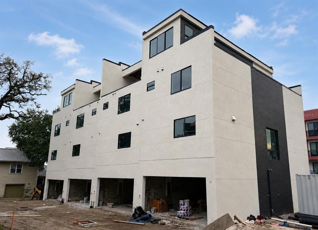 A multi-story modern residential building under construction with a light stucco facade and dark brick — 2119 N OLA AVENUE UNIT 2, TAMPA, FL