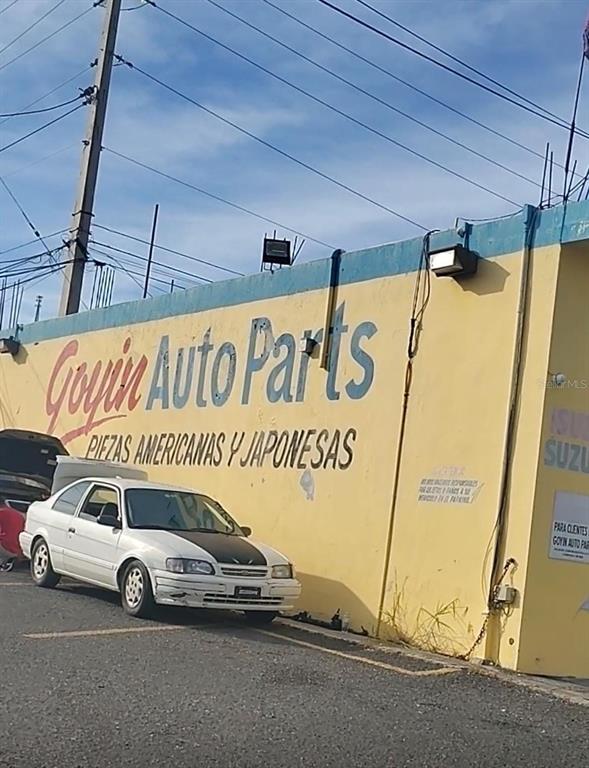 A white sedan is parked in front of a yellow building labeled Goyin Auto Parts — 113 Calle 25 de julio CALLE 25 DE JULIO, YAUCO, PR
