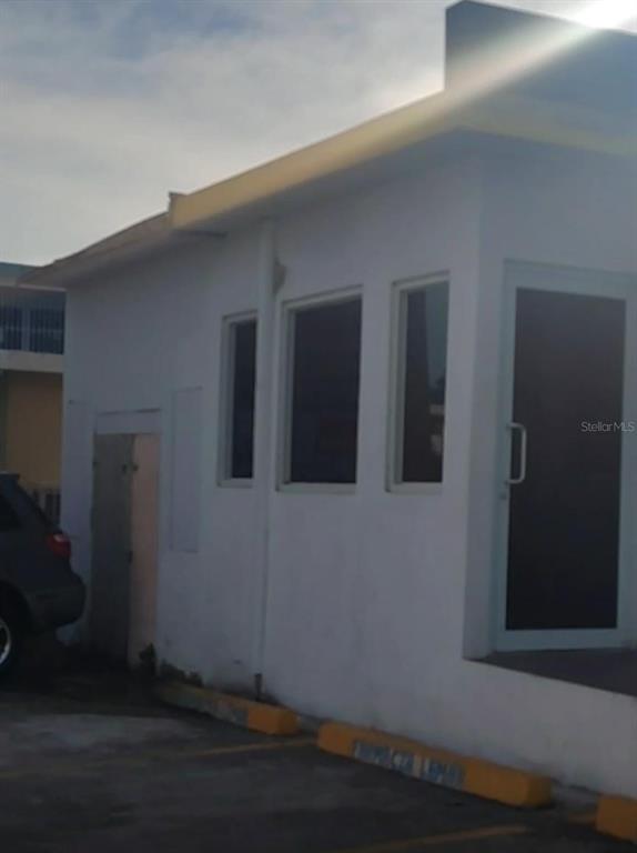 A white commercial building exterior features a glass door, two windows, and parking spaces — 113 Calle 25 de julio CALLE 25 DE JULIO, YAUCO, PR