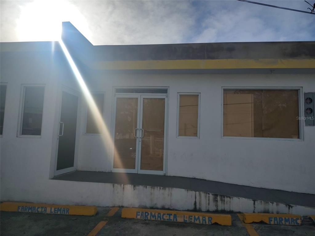 The exterior of a white commercial building features a ramp leading to a glass entrance — 113 Calle 25 de julio CALLE 25 DE JULIO, YAUCO, PR
