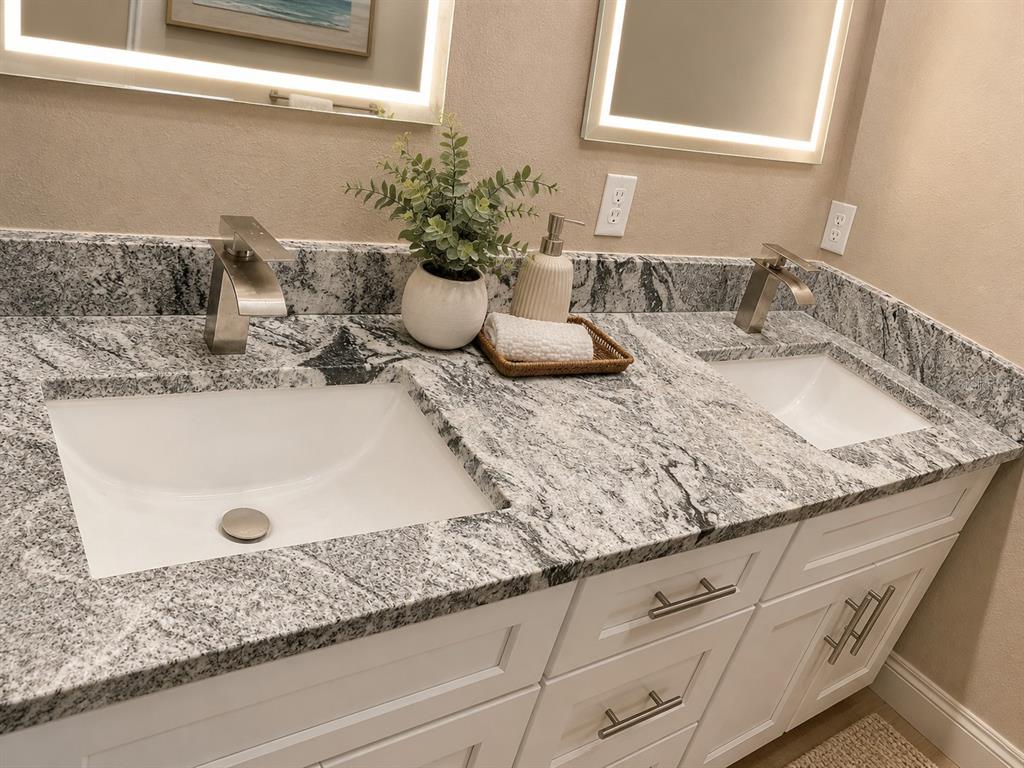 A double vanity bathroom features white cabinets, granite countertops, and two rectangular undermount sinks — 14910 LAURIE LANE, TAMPA, FL