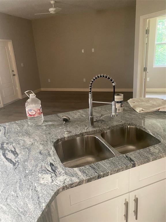 A kitchen island features a stainless steel double sink, gooseneck faucet, and granite countertops — 14910 LAURIE LANE, TAMPA, FL