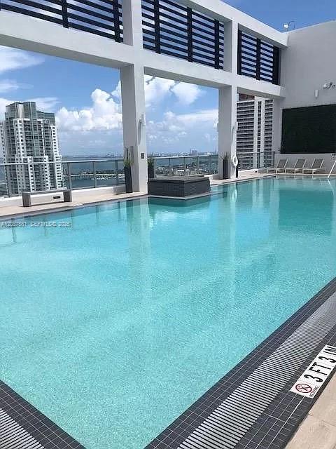 An outdoor rooftop swimming pool overlooks a city skyline and a body of water — 151 SE 1st St # 2405, Miami FL 33131, MIAMI, FL