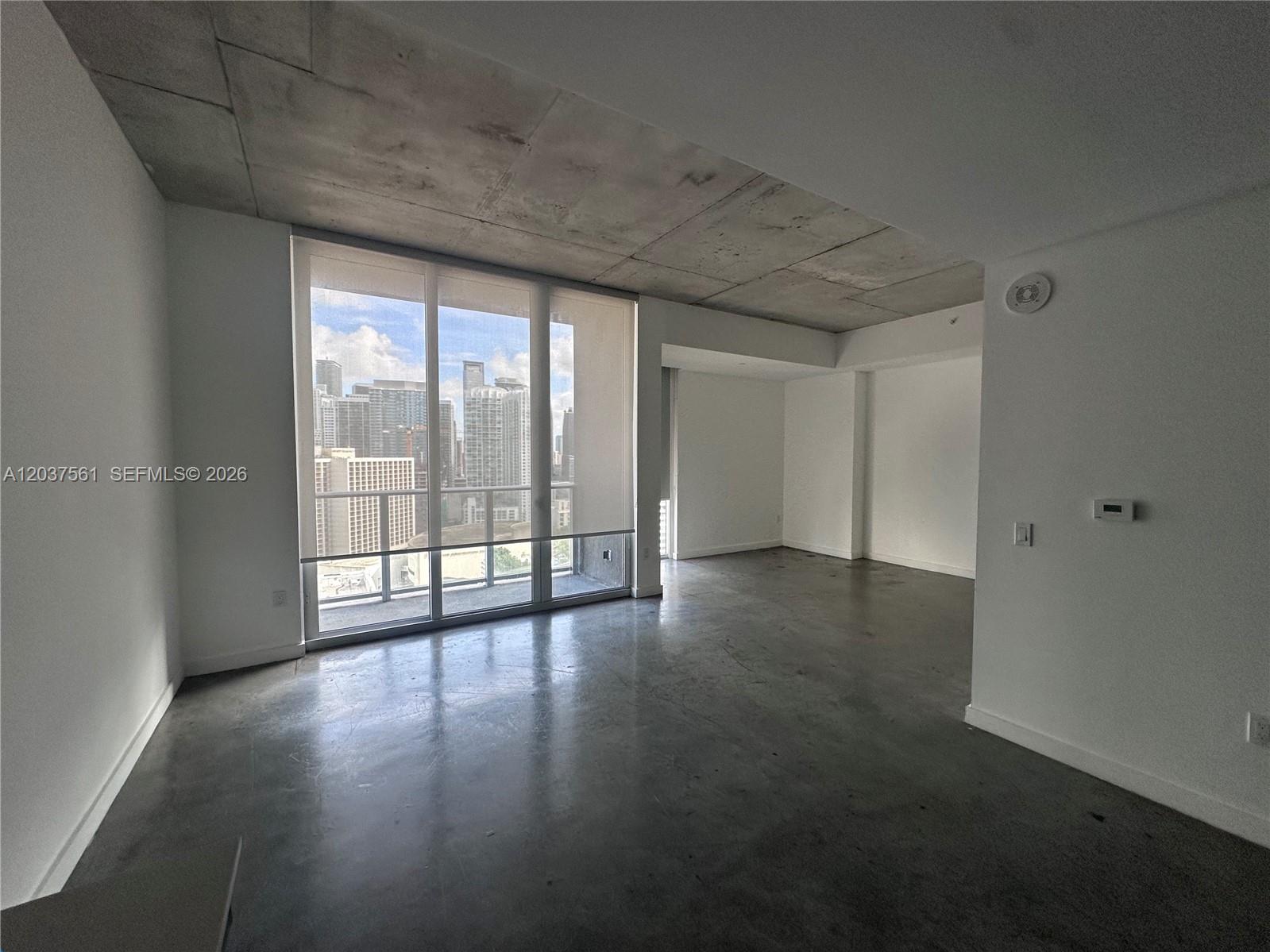 An unfurnished room features concrete floors, an exposed concrete ceiling, and floor-to-ceiling windows — 151 SE 1st St # 2405, Miami FL 33131, MIAMI, FL