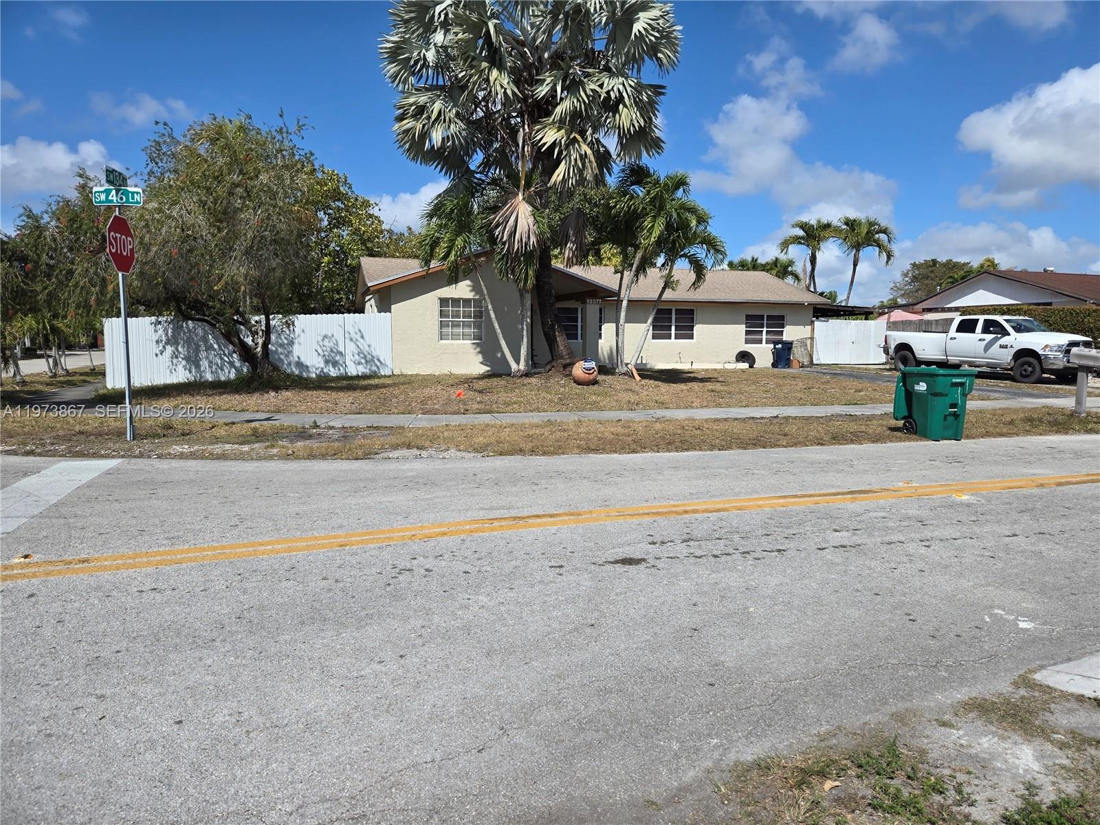 A single-story house with a palm tree in the front yard and a white fence — 13377 SW 46th Ln, Miami FL 33175, MIAMI, FL