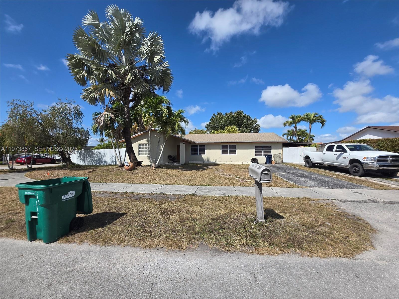 A single-story house with a palm tree, a driveway, and a green trash bin outside — 13377 SW 46th Ln, Miami FL 33175, MIAMI, FL