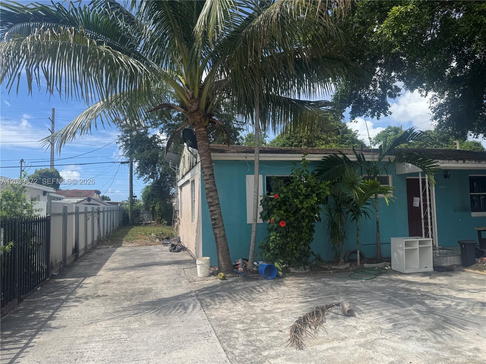 A turquoise house with a palm tree and a concrete driveway in the front yard — 3320 NW 87th Ter, Miami FL 33147, MIAMI, FL