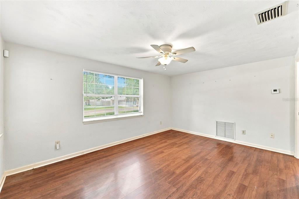 An empty room with light gray walls, wood-look flooring, a ceiling fan, and a window — 44 VOLUSIA DRIVE, DEBARY, FL