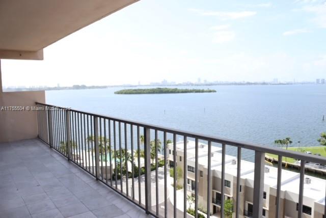 A balcony with a metal railing overlooks a body of water and a residential complex — 1800 NE 114th St # 1108, Miami FL 33181, MIAMI, FL