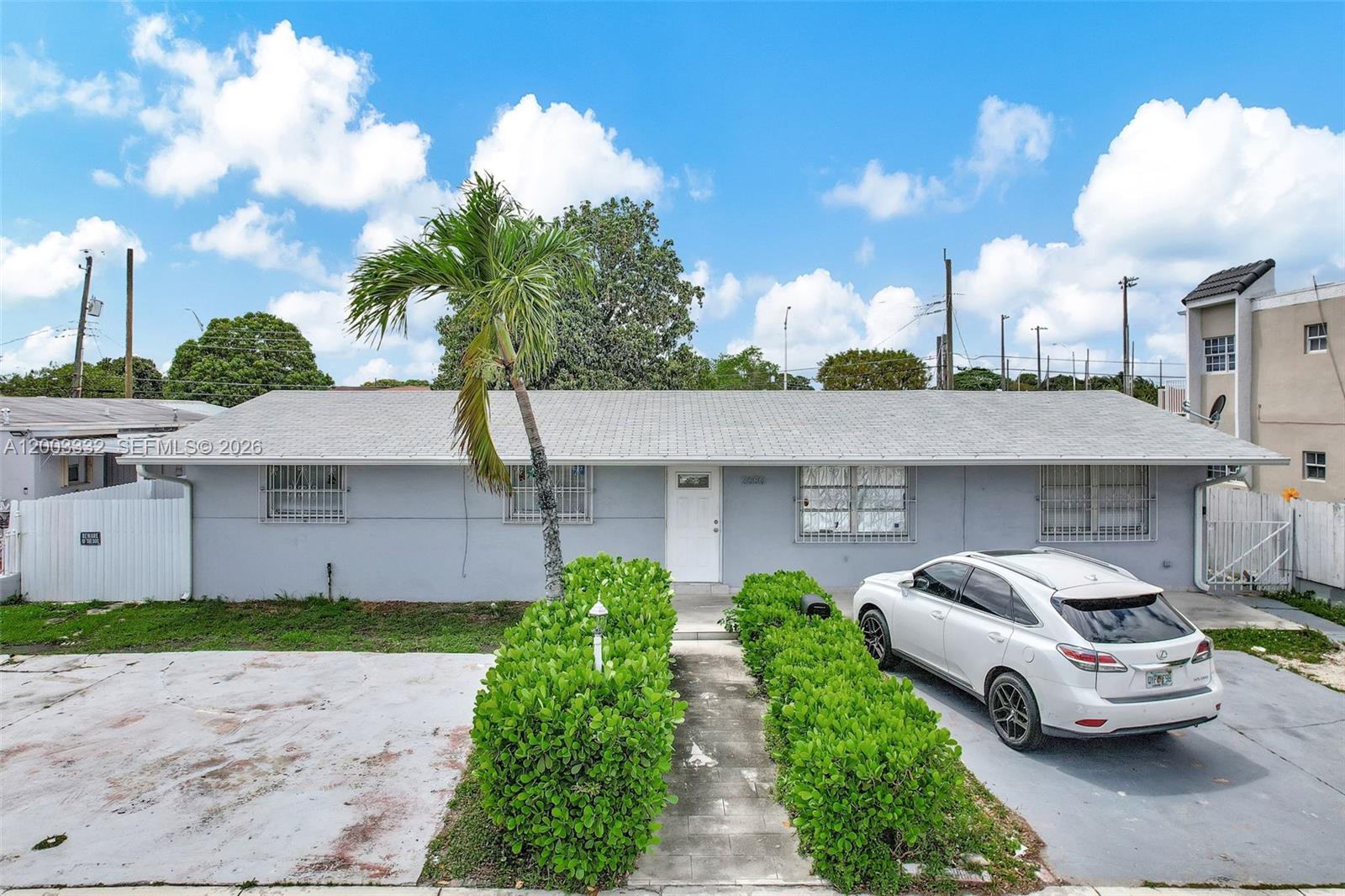 A single-story gray house with a palm tree, hedges, and a parked white SUV — 2650 W 8th Ave, Hialeah FL 33010, HIALEAH, FL