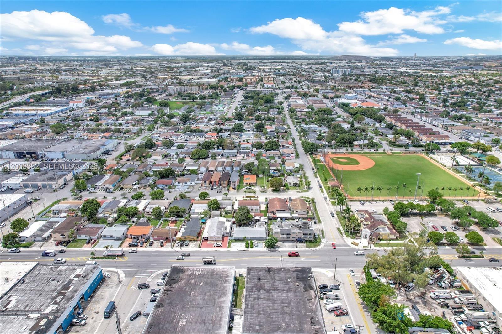 An aerial view shows a residential neighborhood with a baseball field and commercial buildings — 2650 W 8th Ave, Hialeah FL 33010, HIALEAH, FL