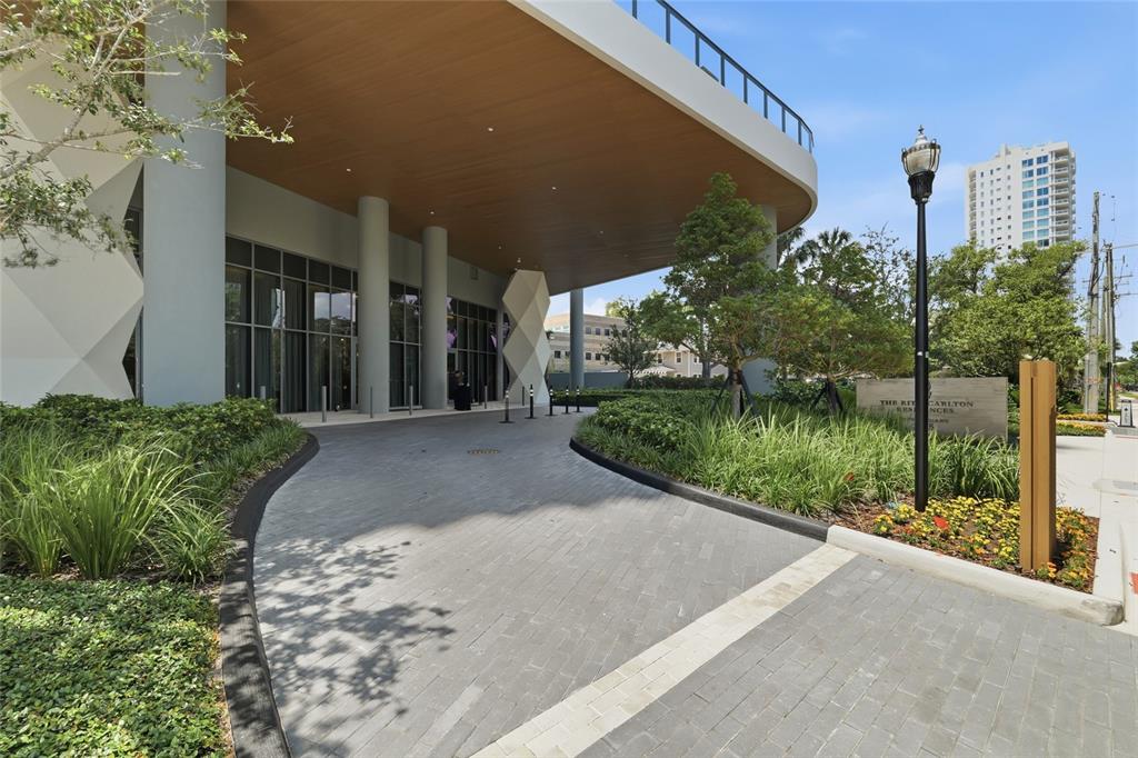 A paved driveway leads to the modern entrance of a building with a large overhang — 3015 S YSABELLA AVENUE UNIT 2102, TAMPA, FL