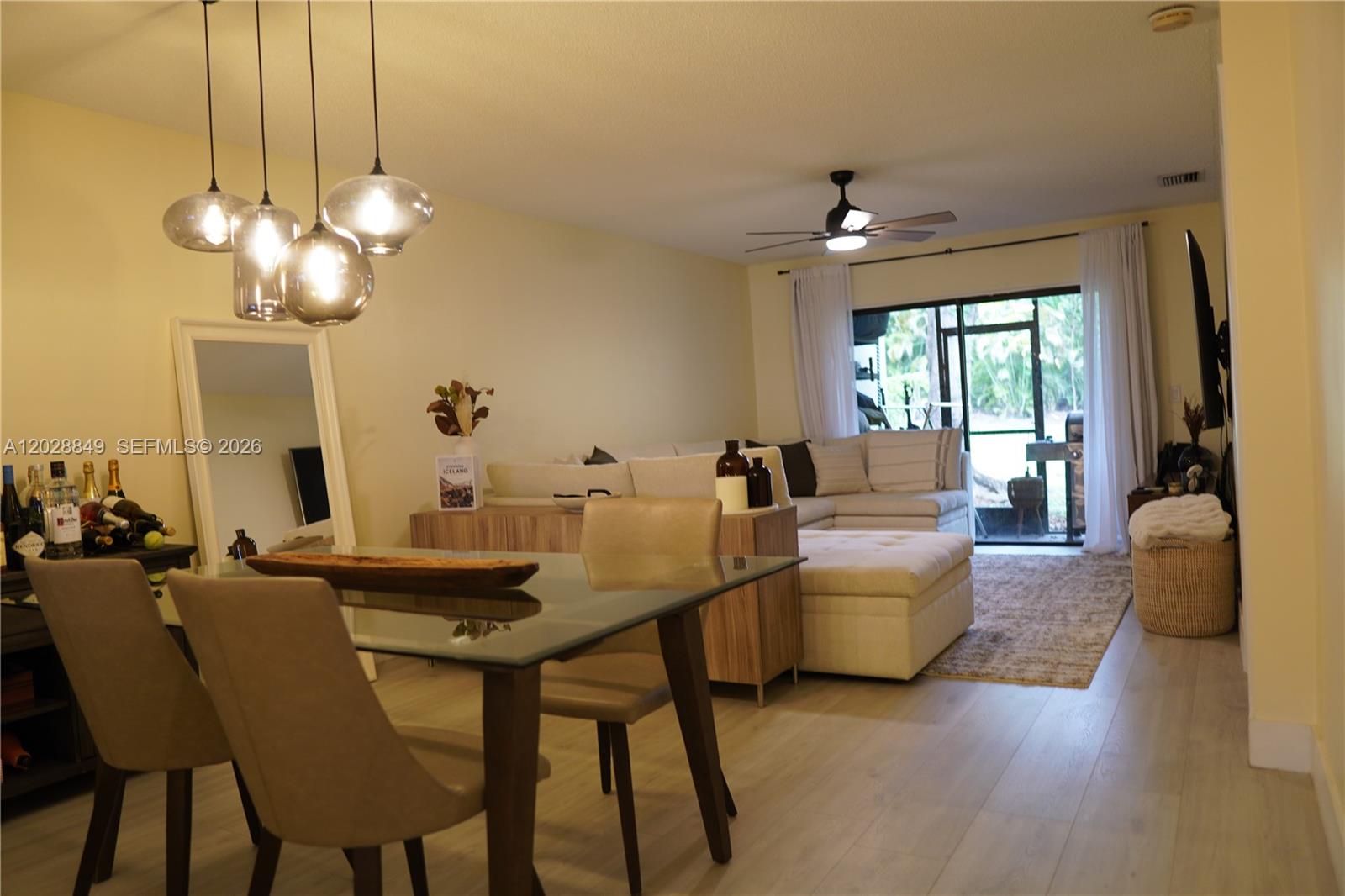 A dining area with a glass table flows into a living room with a sectional sofa — 453 Lakeview Dr # 2, Weston FL 33326, WESTON, FL
