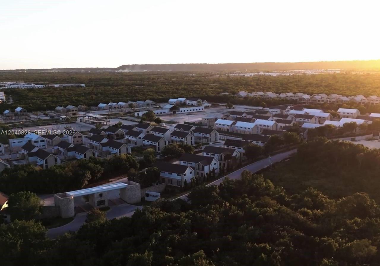 An aerial view shows a residential development with multiple houses surrounded by dense green vegetation — vistta cana, FL