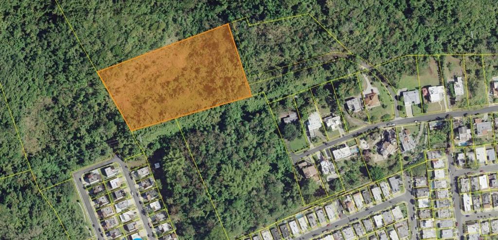 An aerial view shows a highlighted rectangular plot of land adjacent to a residential neighborhood — ESTANCIAS DEL TURABO, CAGUAS, PR