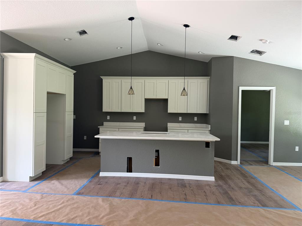 A kitchen under construction features white cabinetry, a gray island, and dark gray walls — 4869 SE 24TH STREET, OCALA, FL
