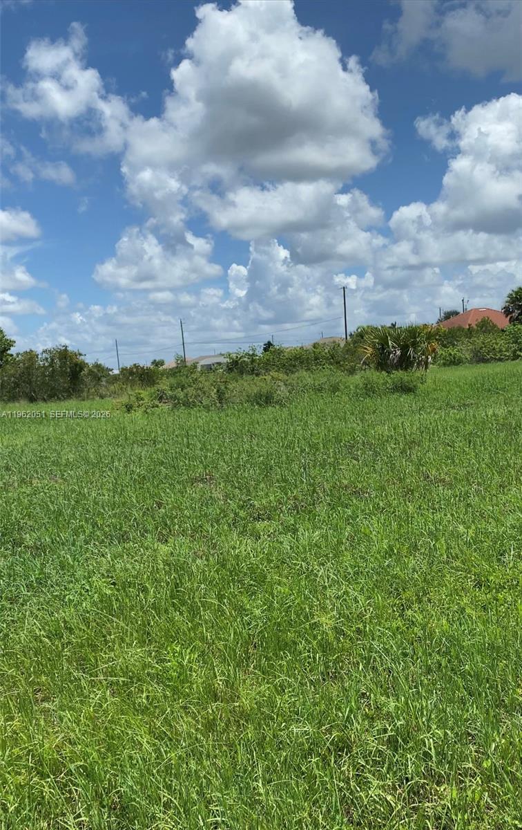 A grassy, undeveloped lot under a bright blue sky with scattered clouds — 2 NW 13TH PL, Cape Coral FL 33993, CAPE CORAL, FL